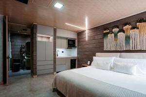 a bedroom with a large bed and a kitchen at Hotel Living by Armoniko in Medellín