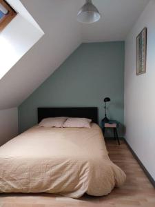 een slaapkamer met een groot bed op zolder bij Charmant appartement au calme avec parking in Besançon