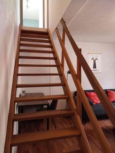 escalera de madera en una habitación con cama en Charmant appartement au calme avec parking en Besançon