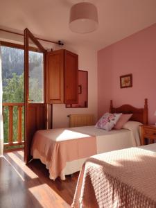 a bedroom with two beds and a window at La Salmonera Cangas de Onís in Caño
