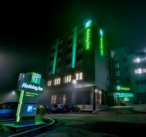 un edificio de hospital con luces verdes por la noche en Holiday Inn - Villingen - Schwenningen, an IHG Hotel en Villingen-Schwenningen