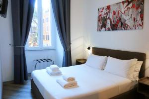 a bedroom with a bed with towels on it at The Roman Way San Giovanni in Rome