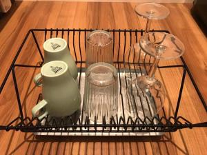 a wire rack with utensils and glasses on a table at Local Hakata apartment No5 in Fukuoka