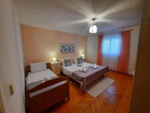 a small room with two beds and a window at Apartman Anita in Kaštela
