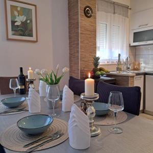 a dining room table with candles and wine glasses at Apartman Anita in Kaštela