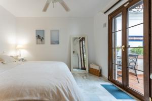 sypialnia z łóżkiem i dużymi szklanymi drzwiami w obiekcie MalagaSuite Mijas Golf Panoramic Views w mieście Mijas Costa