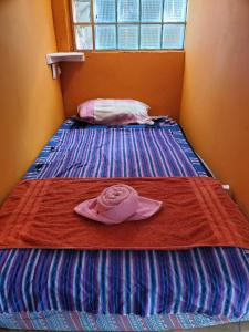 a pink hat sitting on top of a bed at The Hub - Centro Sakbe in San Juan La Laguna