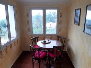 ein Esszimmer mit einem Tisch, Stühlen und Fenstern in der Unterkunft Casa del Sorriso in Elmo