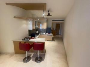 una cucina con due sedie rosse e un bancone di Luxurious 5 Star Studio Apartment a Calcutta