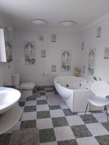 a bathroom with a tub and a sink and a toilet at Oak Tree Farm in Potter Heigham