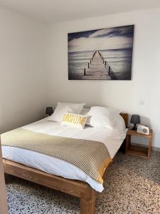 - une chambre dotée d'un lit avec une photo sur le mur dans l'établissement L Abri-côtier Appartements, à Saintes-Maries-de-la-Mer