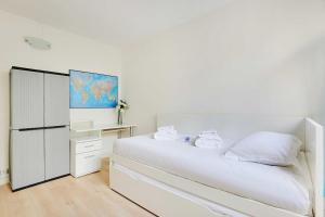 a white bedroom with a white bed and a desk at Cozy apartment - Paris Porte de Versailles in Paris