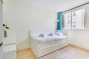a white bedroom with a bed and a window at Cozy apartment - Paris Porte de Versailles in Paris