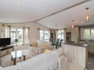 a living room with a couch and a table at Gwydn Lodge in Lymington