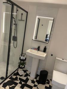 a bathroom with a sink and a shower with a mirror at Crown Street room only accommodation in Seahouses