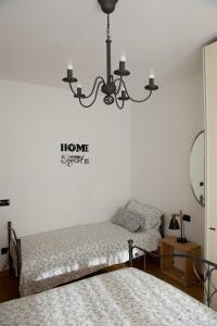 1 dormitorio con 2 camas y lámpara de araña en Pelèr13, en Riva del Garda