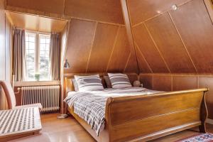 een bed in een kamer met een houten muur bij De Kievit in Vogelenzang