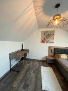 ein Wohnzimmer mit einem Schreibtisch und einem Sofa in der Unterkunft Nuits en Sologne in Romorantin