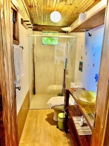 a bathroom with a shower and a toilet and a sink at Casa de Terra in Caraíva