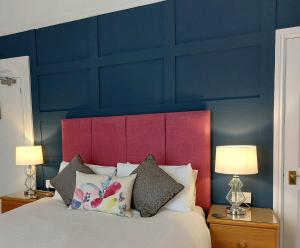 sypialnia z niebieską ścianą i łóżkiem z poduszkami w obiekcie Harmony Bed and Breakfast w mieście Torquay