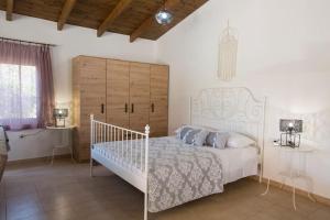 a bedroom with a white bed with a wooden headboard at Serenity Studio Beach Home in Afantou