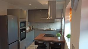 a kitchen with a stainless steel refrigerator and a counter at Stunning 3 bed House sleeps 5-6, WiFi, OFF Street Parking in Nottingham close to M1 in Nottingham