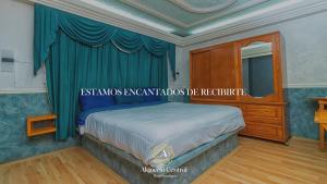 a bedroom with a king sized bed with blue curtains at Alquería Central hotel in Tlaxco de Morelos