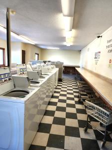 a laundry room with a row of machines on a checkered floor at Grantsburg Inn in Grantsburg