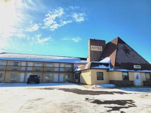 a hotel building with a snow covered roof at The Trail Inn - Grantsburg, WI - 703 WI-70 in Grantsburg