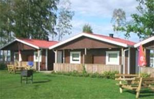 een huis met een tuin met banken ervoor bij Hindås Lake Camp in Hindås