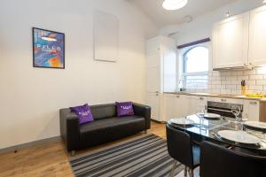 ein Wohnzimmer mit einem schwarzen Sofa und einem Tisch in der Unterkunft Pillo Rooms Serviced Apartments - Salford in Manchester