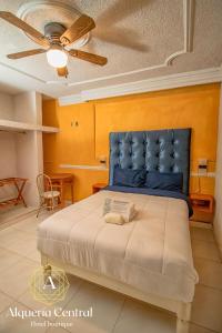 a bedroom with a large bed with a blue headboard at Alquería Central hotel in Tlaxco de Morelos