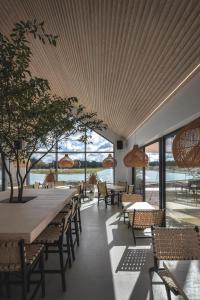 a dining room with tables and chairs and windows at Vanduo Marse in Tuliejai