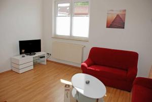 a living room with a red couch and a tv at Ferienhaus am Sonnensteg in Ostseebad Sellin