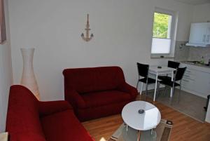 a living room with a red couch and a table at Ferienhaus am Sonnensteg in Ostseebad Sellin