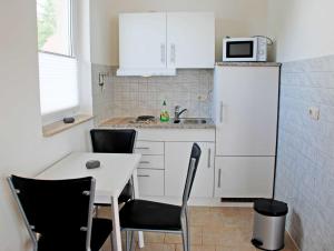 オストゼーバート・ゼリンにあるFerienhaus am Sonnenstegの小さなキッチン(テーブル、白い冷蔵庫付)
