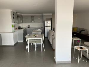 Golden rays chalet في مادبا: مطبخ وغرفة معيشة مع طاولة وكراسي