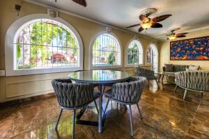 a dining room with a glass table and chairs at Luxurious San Juan Villa with Pool - Walk to Beach! in San Juan