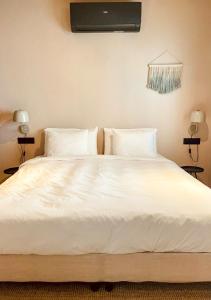 a large white bed with white sheets and pillows at Casita 10 Málaga, holiday home with roof terrace in Málaga