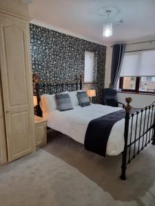 1 dormitorio con 1 cama con pared en blanco y negro en Denham Guest House en Denham