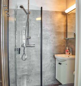 La salle de bains est pourvue d'une douche et d'un lavabo. dans l'établissement First Camp Sjöstugan - Älmhult, à Älmhult