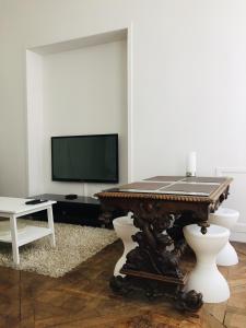 a living room with a table and a tv at Appartement Marais in Paris