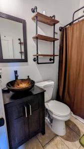 a bathroom with a toilet and a sink and a mirror at Farmhouse for 6 In Charleston Black House in Charleston