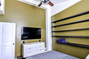 a bedroom with a bed and a tv on a wall at Farmhouse for 6 In Charleston Black House in Charleston