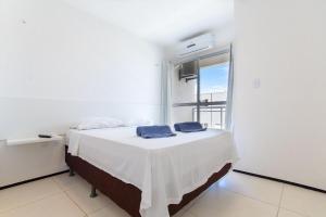 Bett in einem Zimmer mit Fenster in der Unterkunft Beach Townhouses #C13 - Acomodação por Carpediem in Aquiraz
