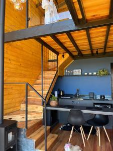 a room with a staircase and a table and chairs at Cabana Cambará in Cambara do Sul