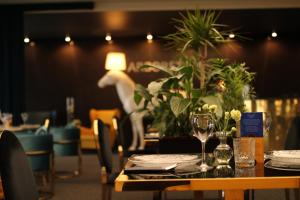 una sala da pranzo con tavolo, bicchieri e piante di Arboretum Hotel a Wolbórz