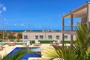 een huis met een patio met uitzicht op de oceaan bij Beach Townhouses #C13 - Acomodação por Carpediem in Aquiraz