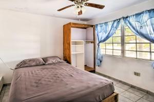Un dormitorio con una cama y un ventilador de techo. en Tropical Oasis Bay Views about 2 Mi to Playa Sardinas, en Culebra