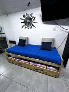 uma cama contra uma parede com um sinal na parede em Winewalker em Ciudad Lujan de Cuyo